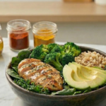 Anti-inflammatory bowl with grilled chicken, broccoli, avocado, quinoa and leafy greens on a marble surface